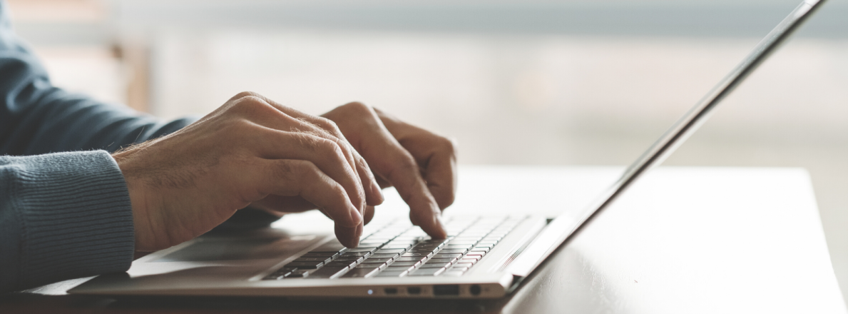 Hands writing on a laptop