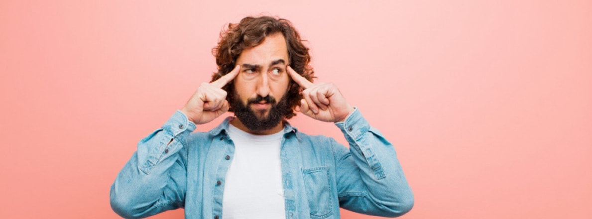 A man pointing both forefingers at his temples