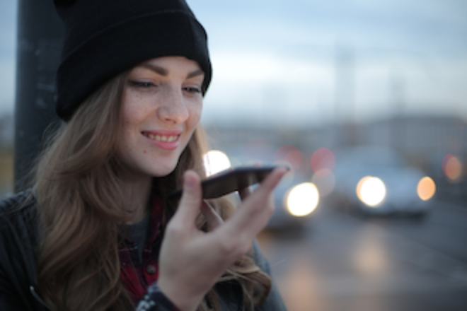 Young woman using voice search on smartphone